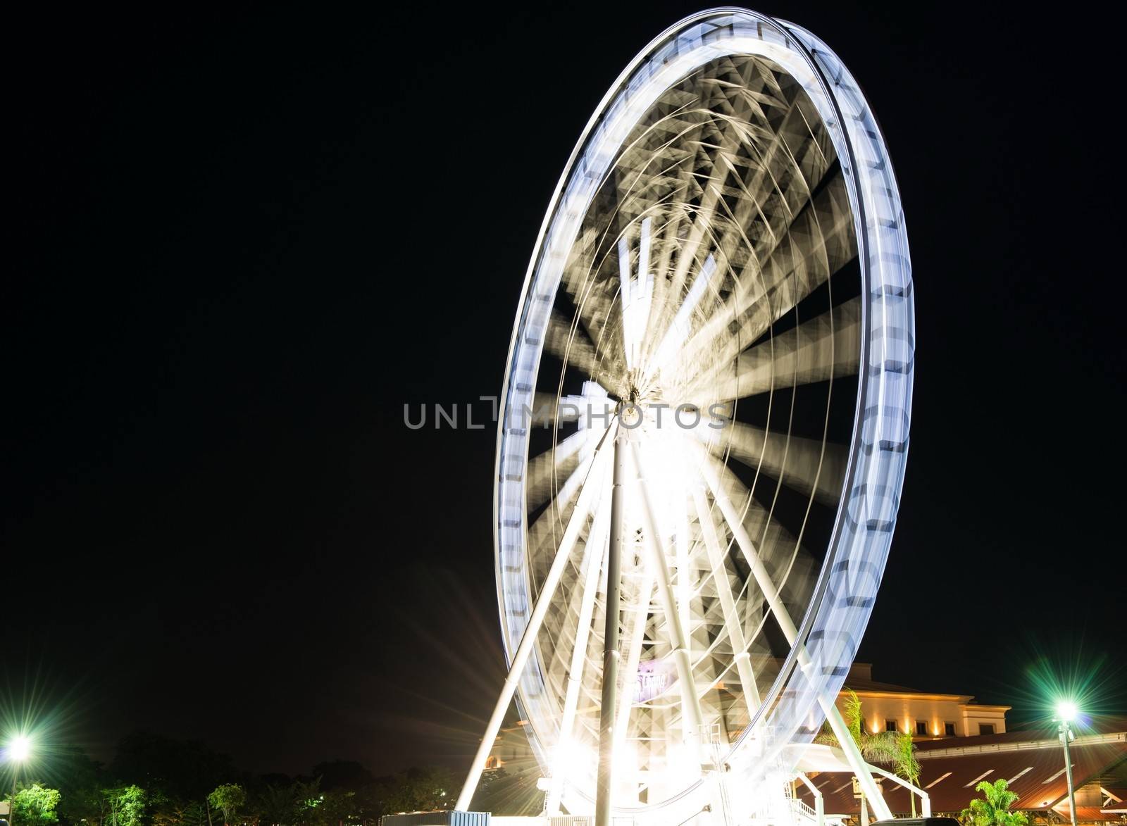 Fairy wheel in an amusement park during night time, taken at slow shutter.