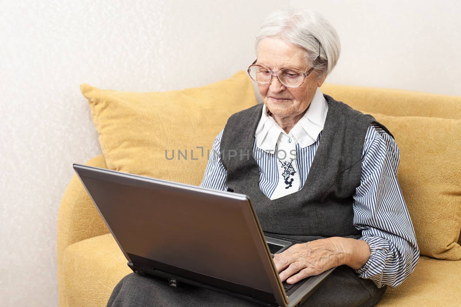 Senior woman using laptop computer by photobac