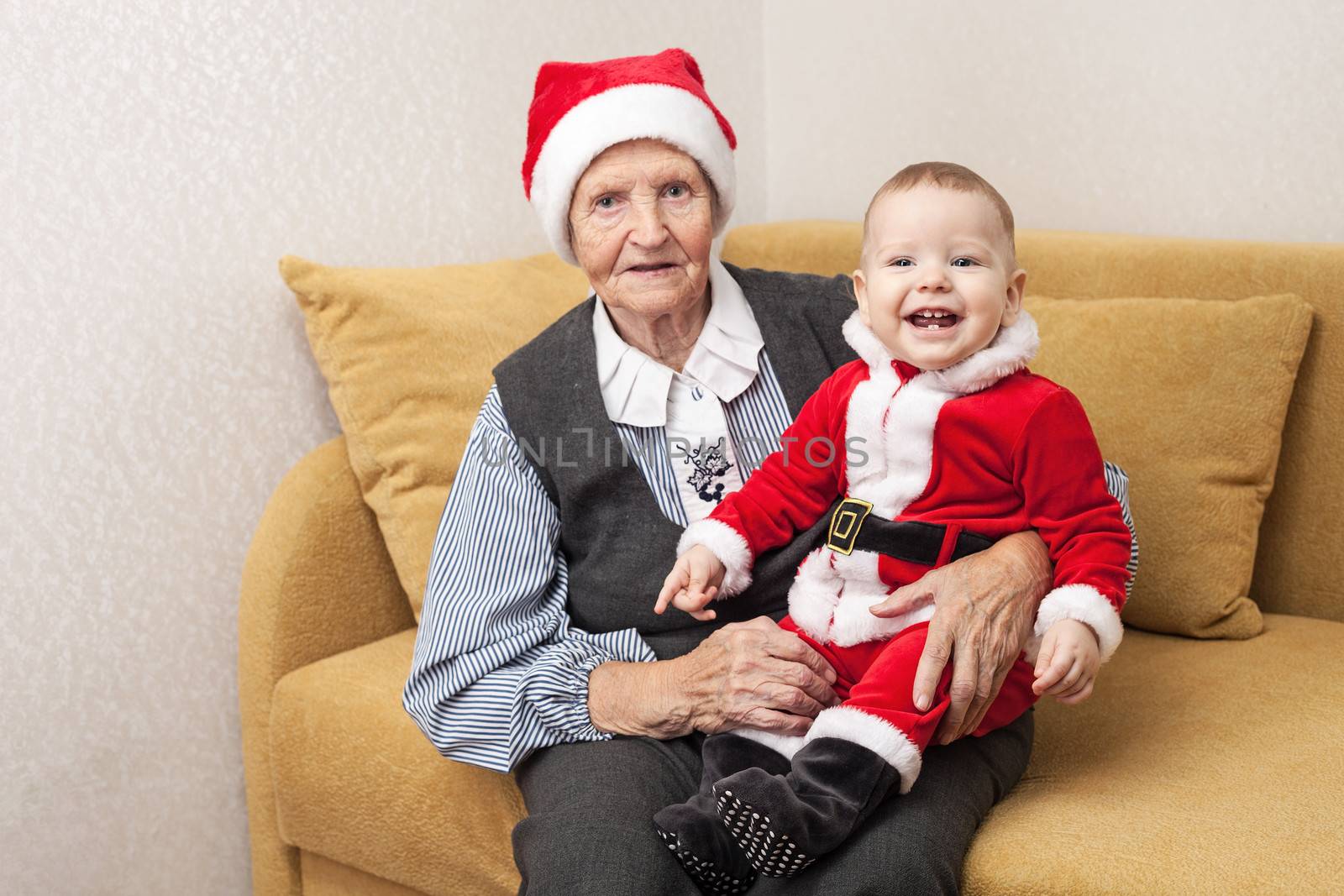 Christmas baby in Santa clothes with grandmother by photobac