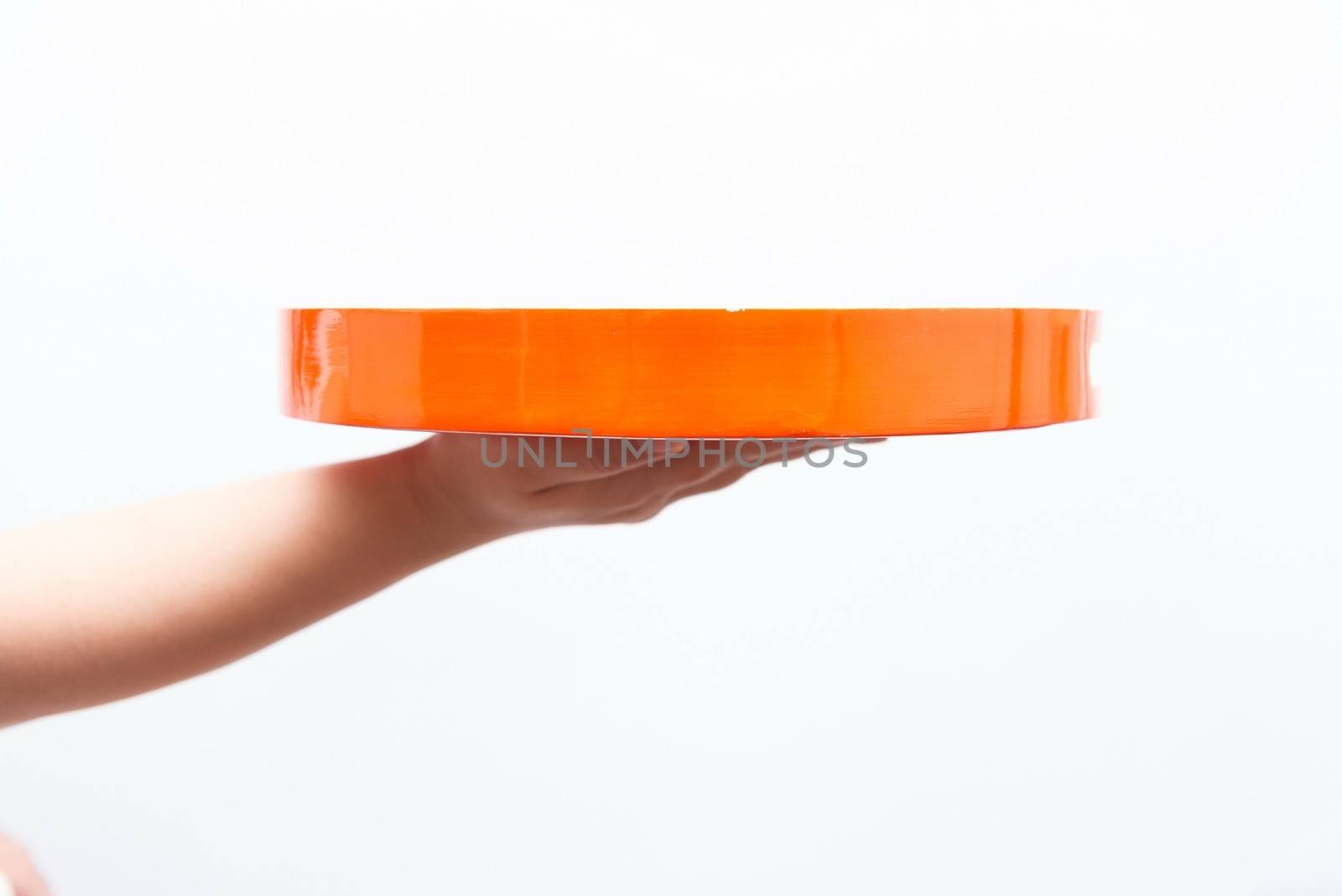 Asian woman holding orange plate, isolated