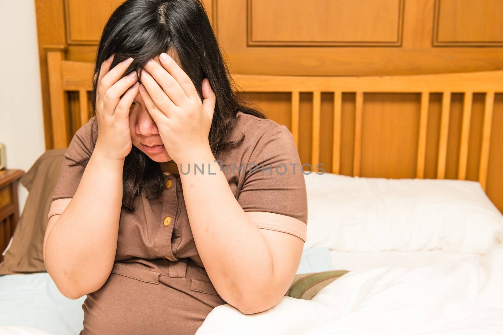 Young thai pregnant woman under stress in bed