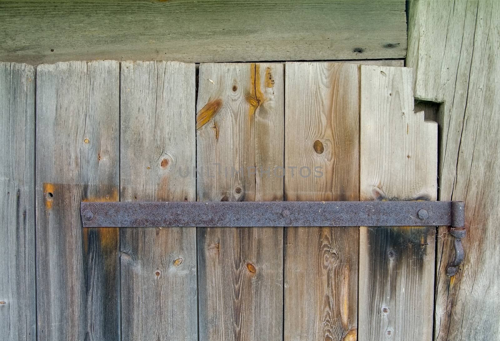 Old wooden door with rusty hinge