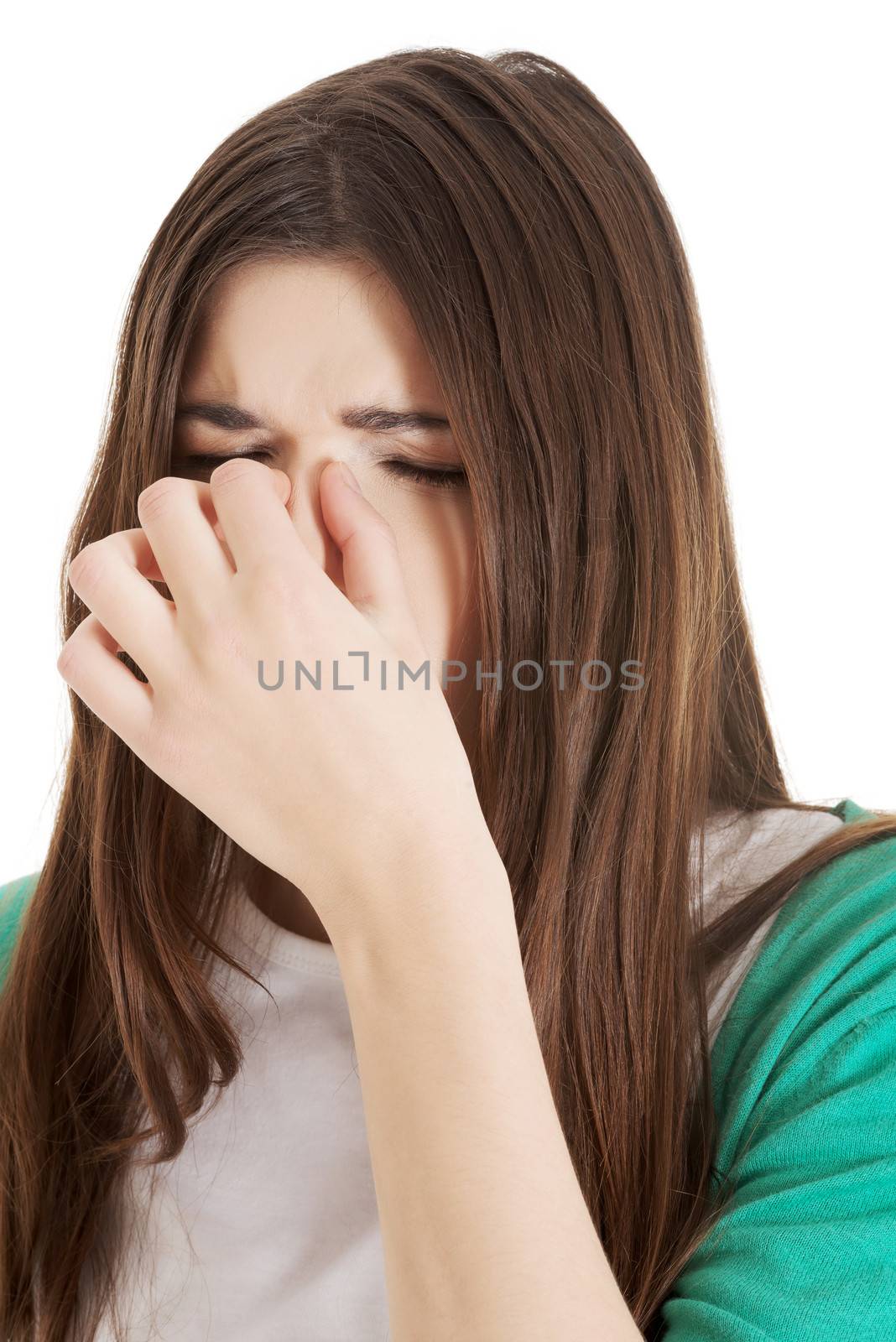 Young beautiful woman with sinus pressure, touching her nose. Isolated on white.