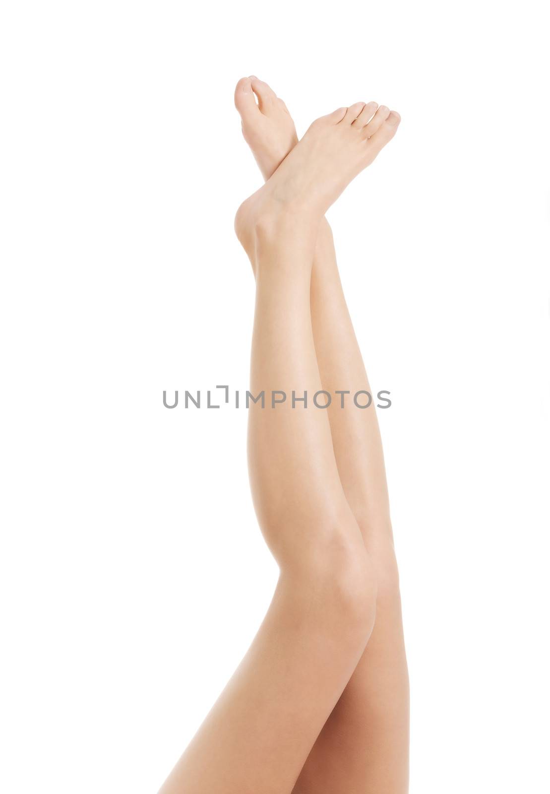 Beautiful smooth female legs streteched up. Isolated on white.