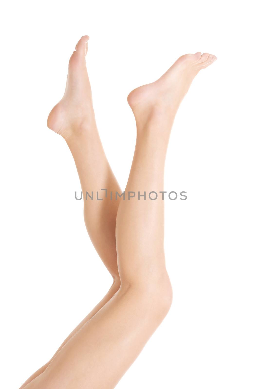 Beautiful smooth female legs streteched up. Isolated on white.