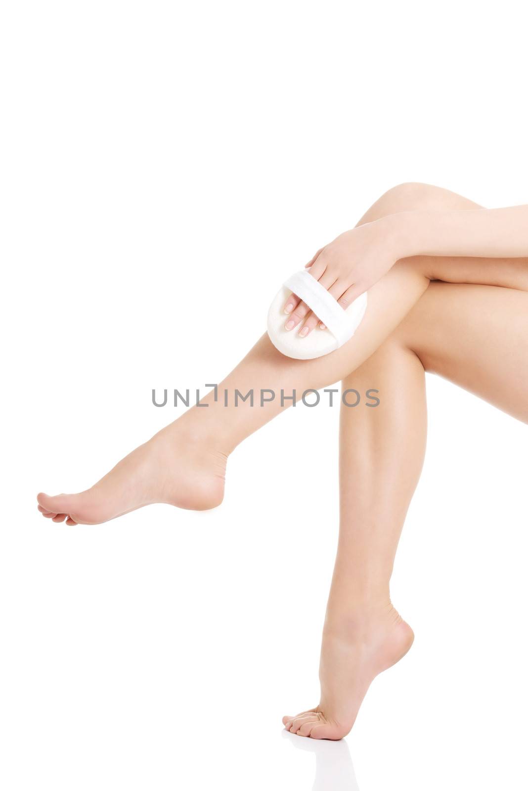 Beautiful woman's legs. Woman is pampering herself. Isolated on white.