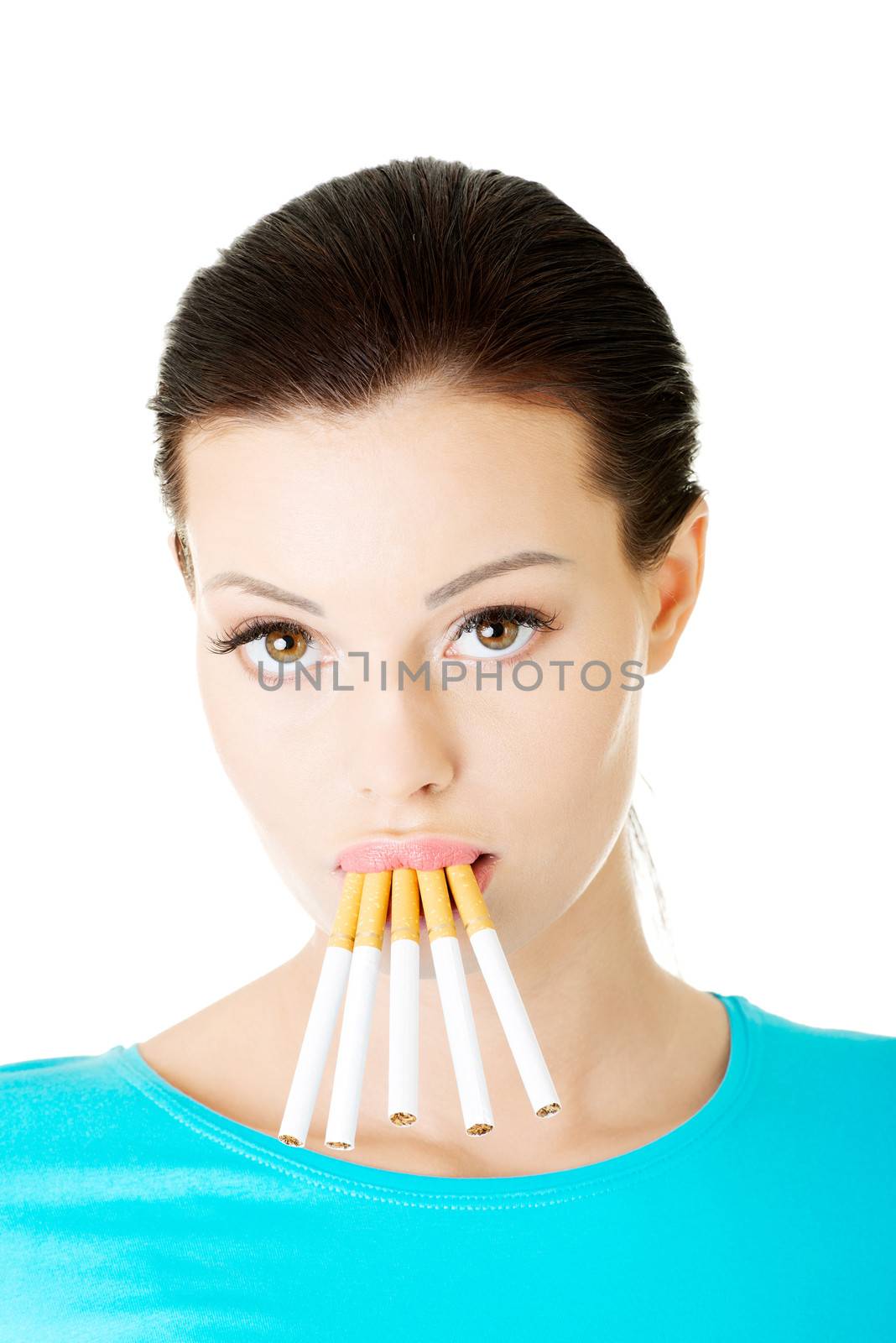 Young beautiful woman with cigarettes in mouth. Isolated on white.