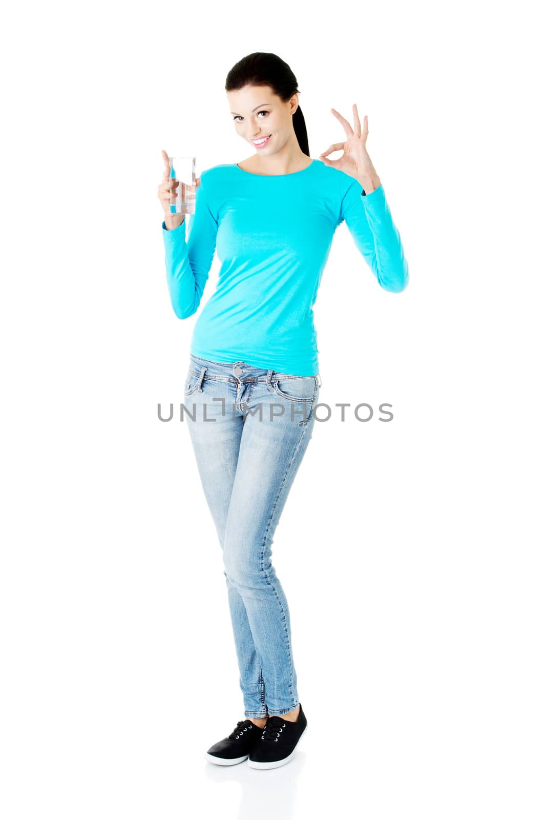 Young casual woman with glass of water. Isolated on white.