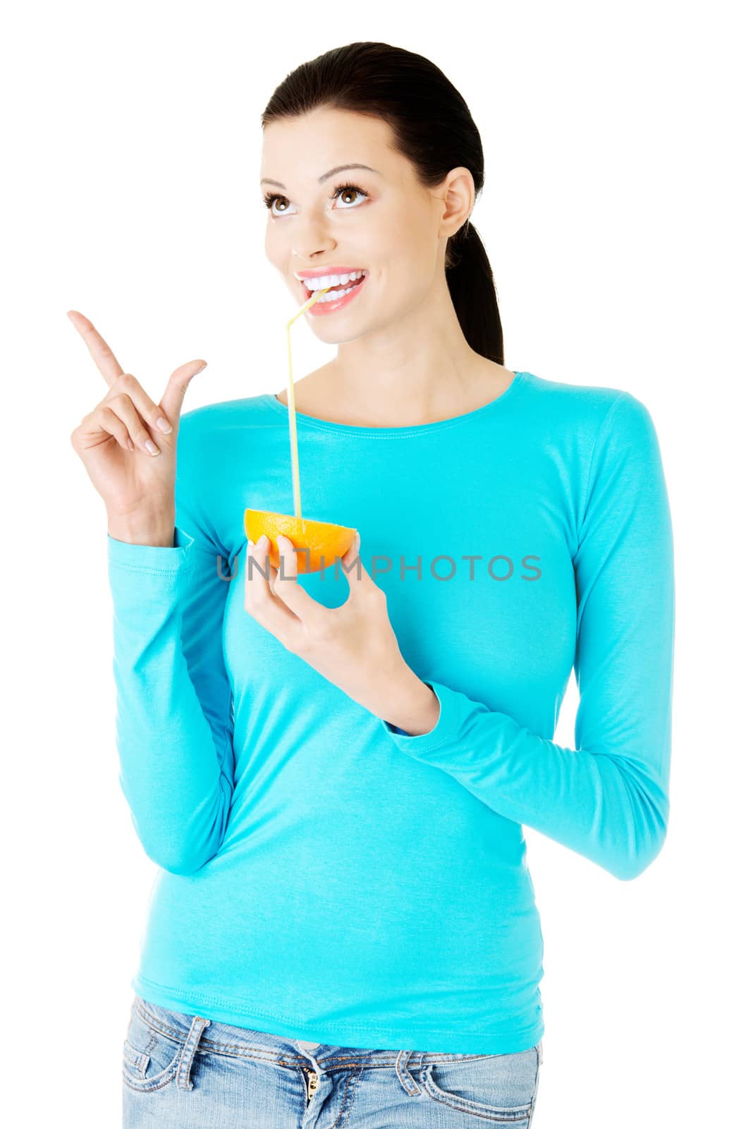 Beautiful young woman drinking juice from orange. Isolated on white.