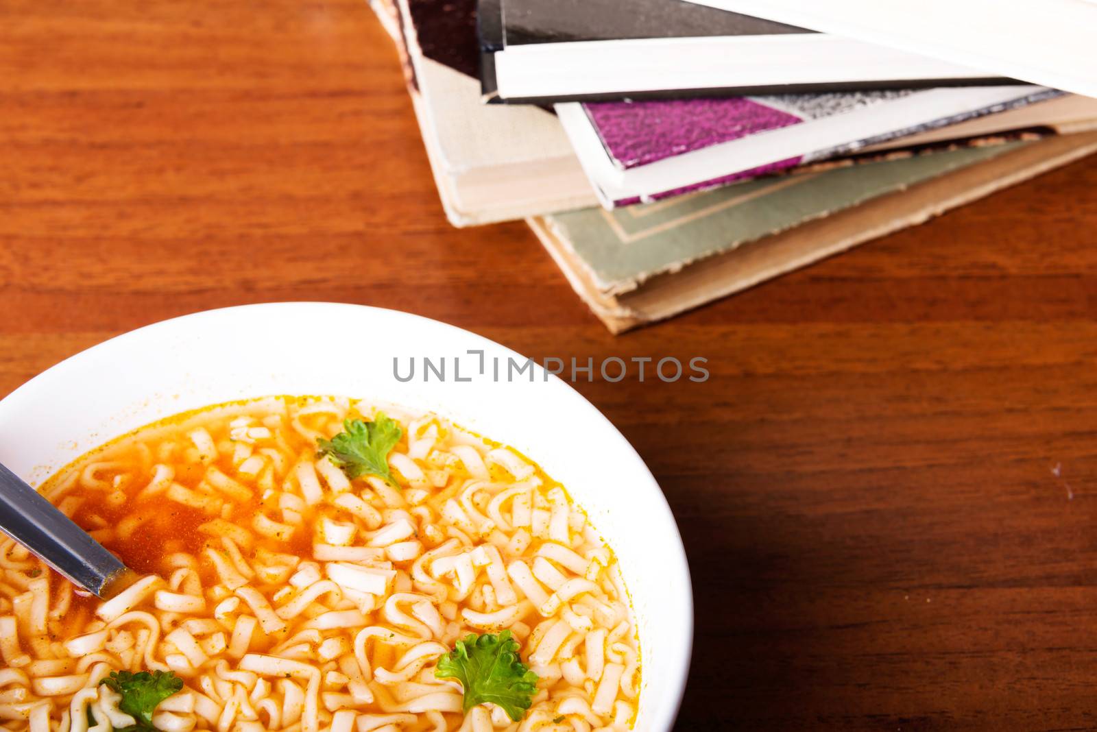 Bowl with soup and pasta lying on a table.