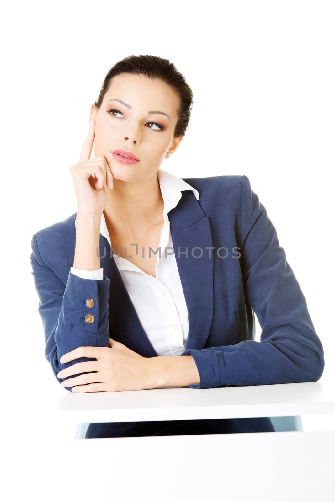 Young business woman sitting and thinking. Isolated on white.