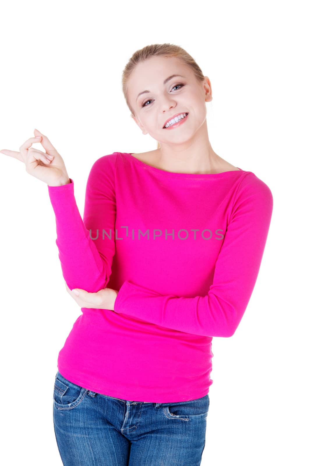 Young casual woman pointing aside. Isolated on white.