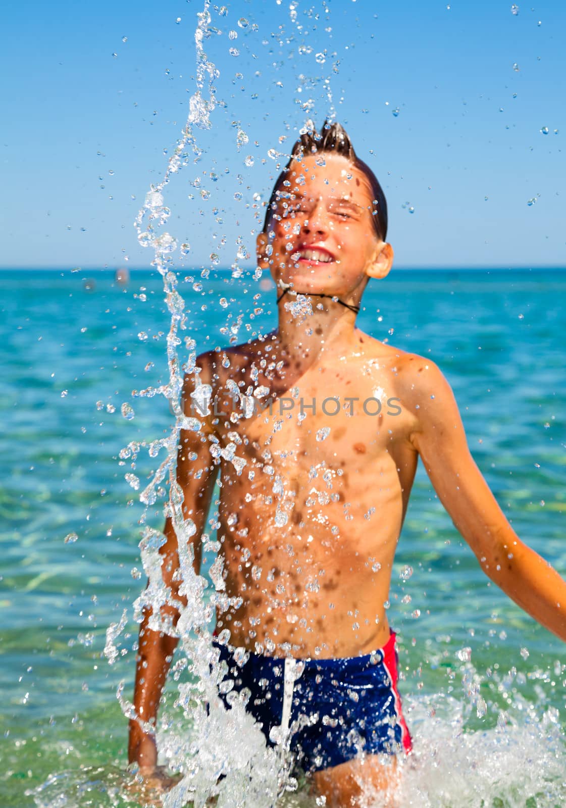 Happy boy enjoying summer day at the sea