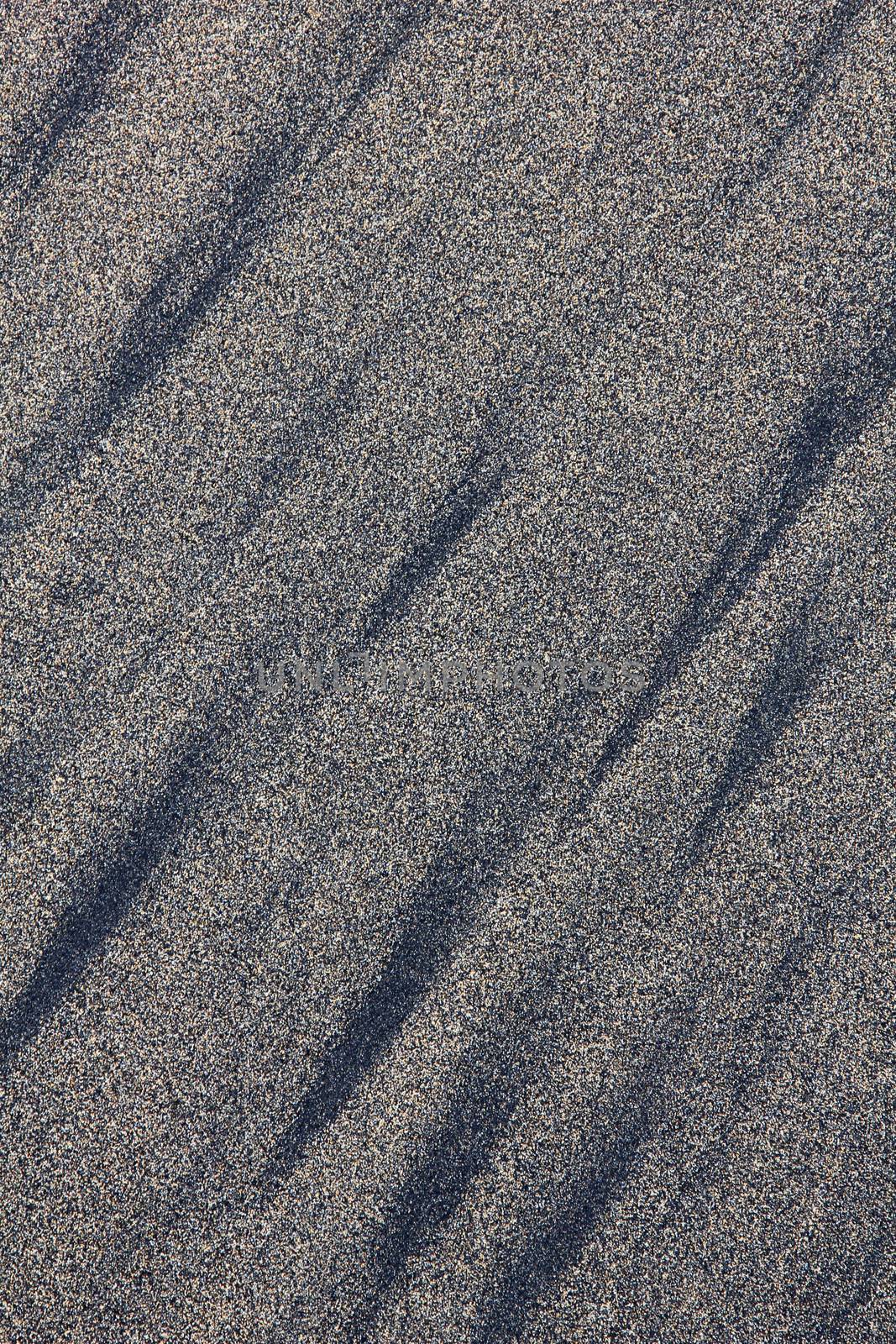 Golden sand with black lines can use as background. Sand from Las Canteras beach. Spain. Canary Islands. Gran Canaria island. Las Palmas de Gran Canaria city. 
