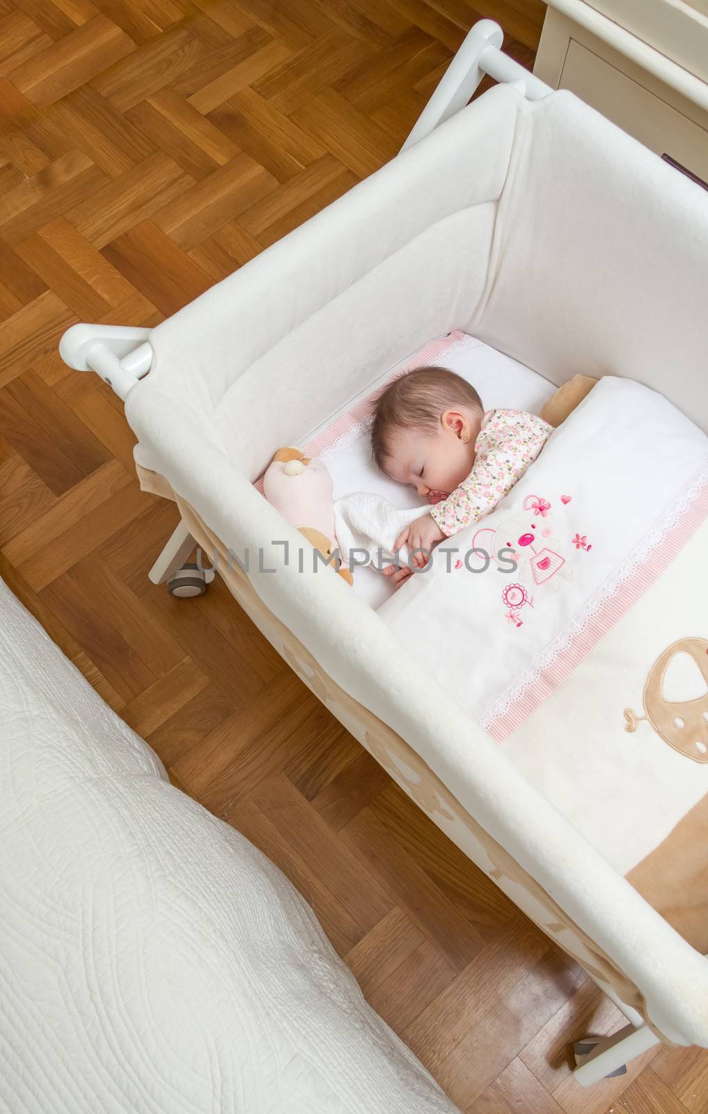 Baby girl sleeping in a cot with pacifier and toy by doble.d