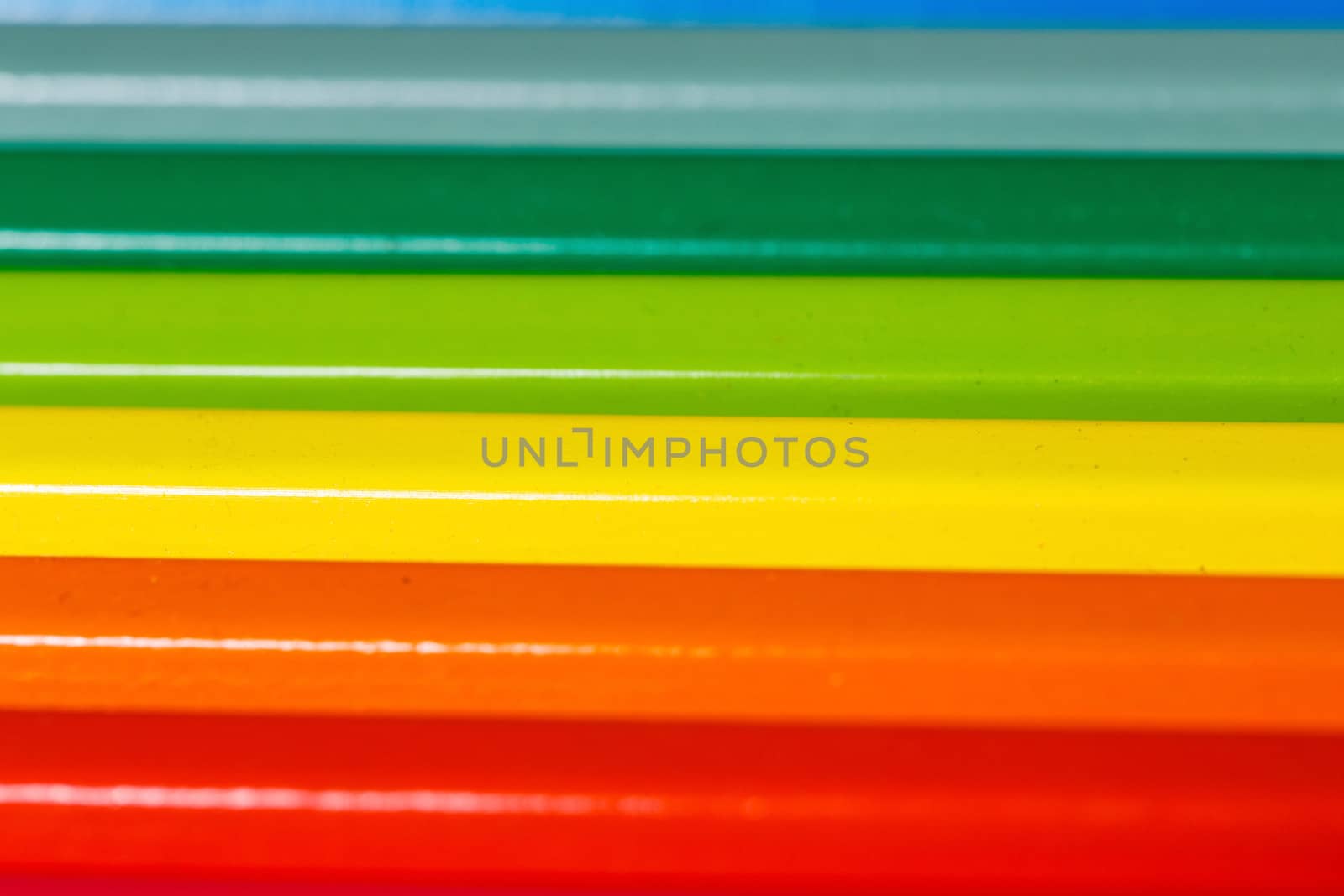 Brightly colored wooden pencils closeup shot background