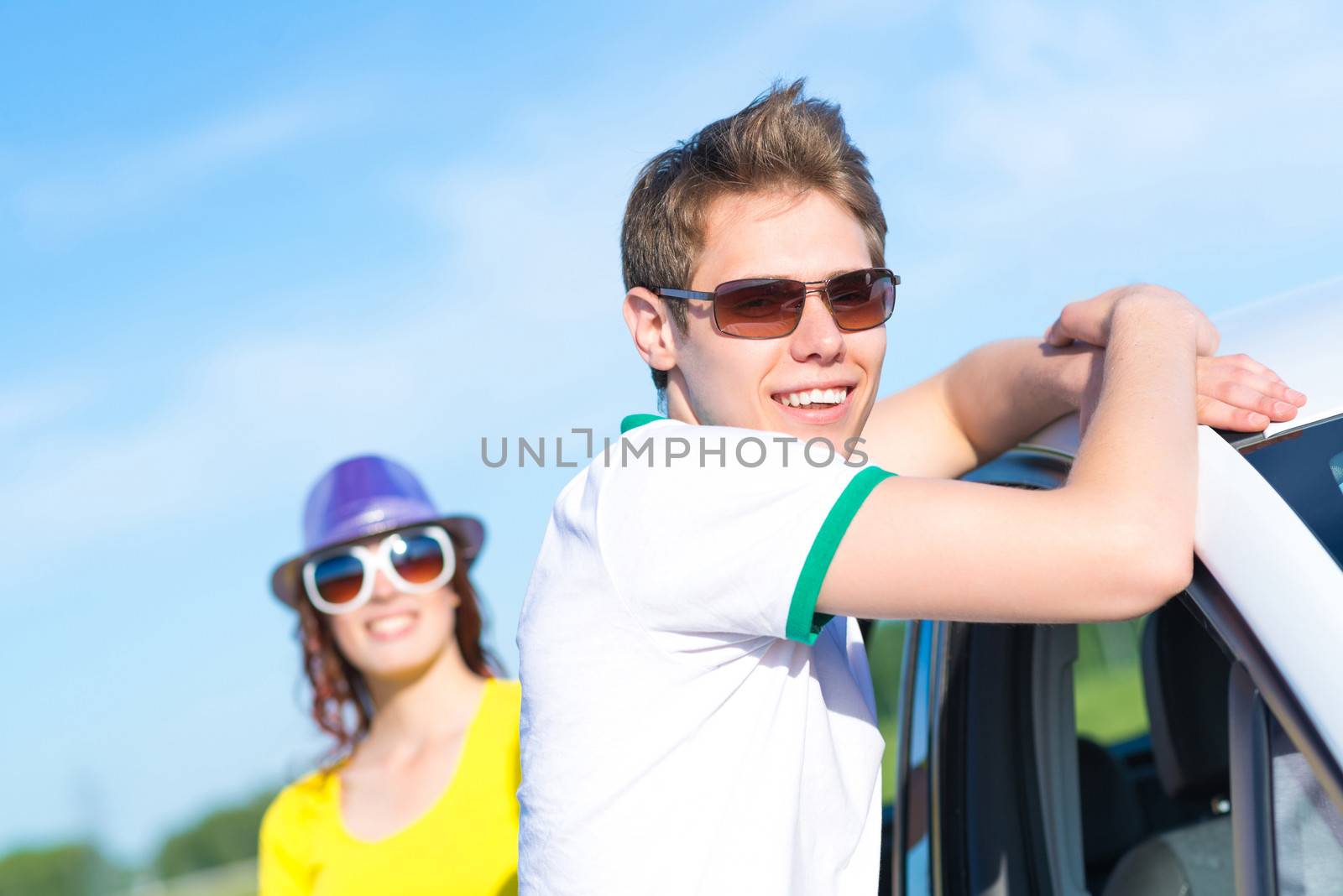 young man in sunglasses standing next to the car, the summer road trip