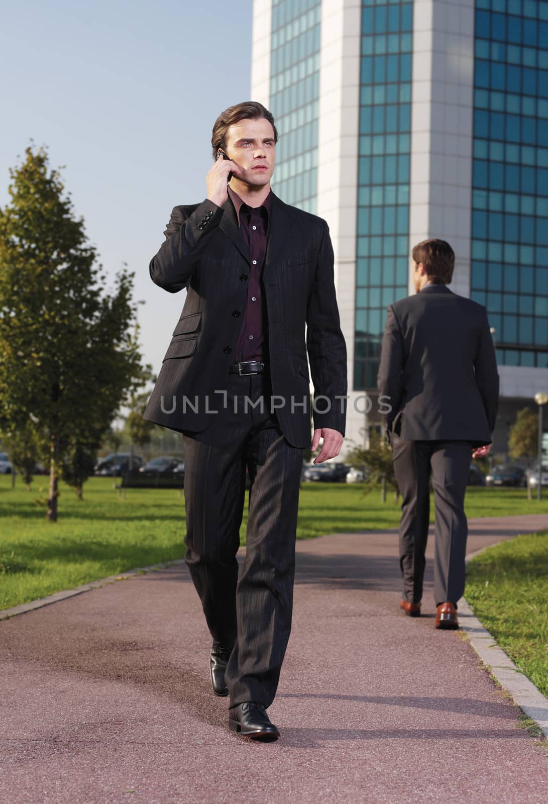 Businessman walking near office a by toocan