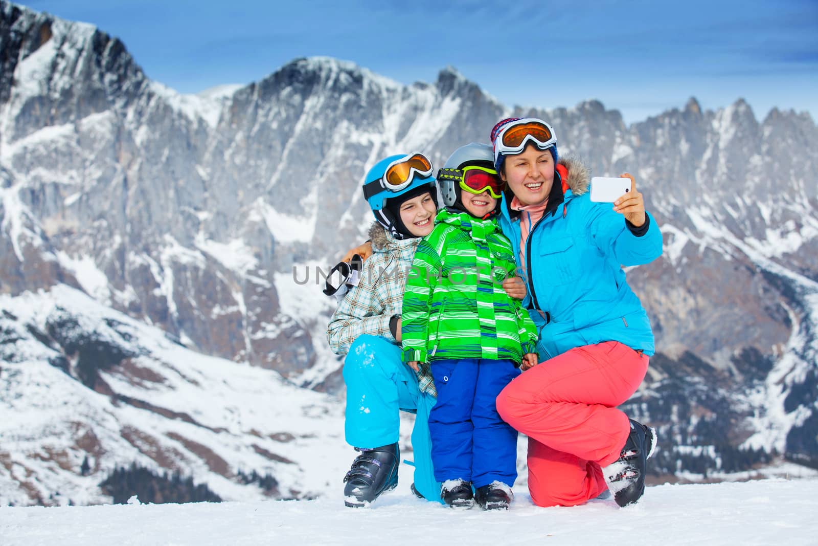 Ski, winter, snow, skiers, sun and fun - family photographed on phone during winter vacations.