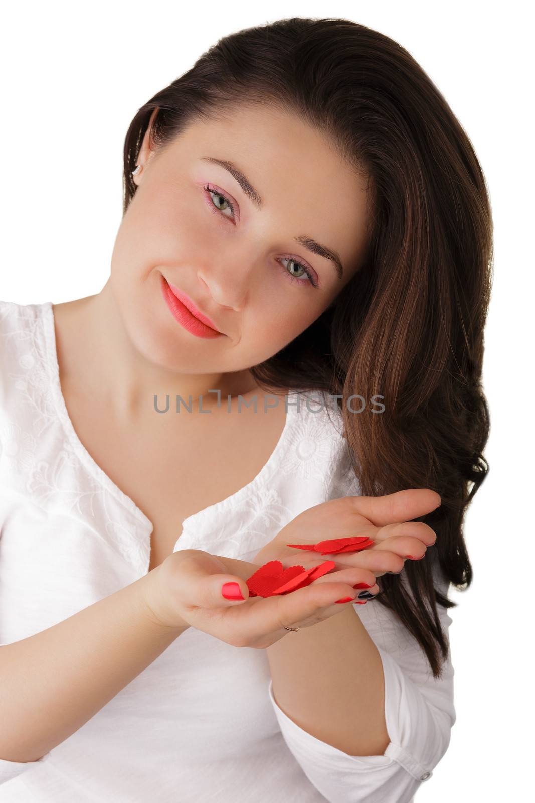 Beautiful girl holding red heart shaped petals.