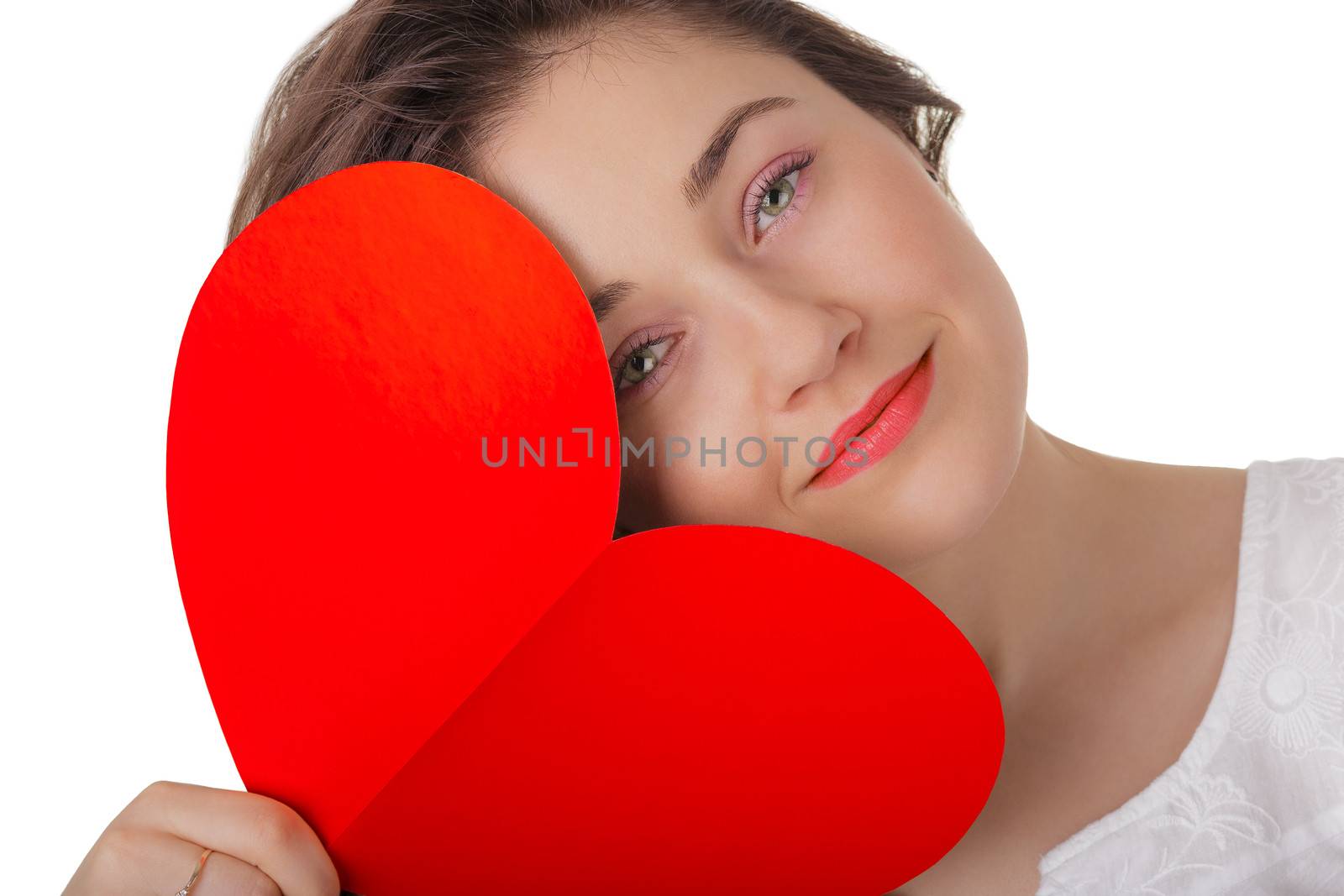 Beautiful girl holding a heart-shaped Valentine’s Day card.