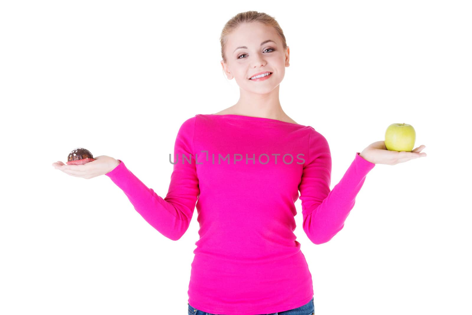 Young casual woman holding an apple and cookie. Isolated on white.