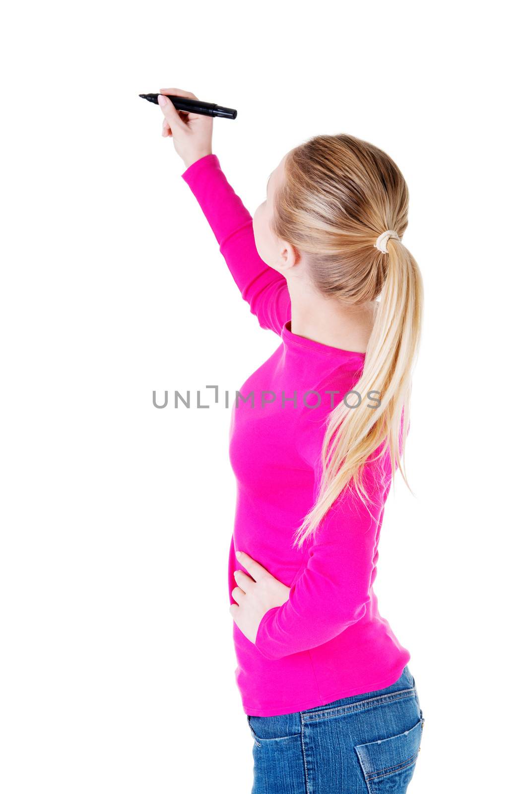 Young casual woman writing on copy space. Back view. Isolated on white.