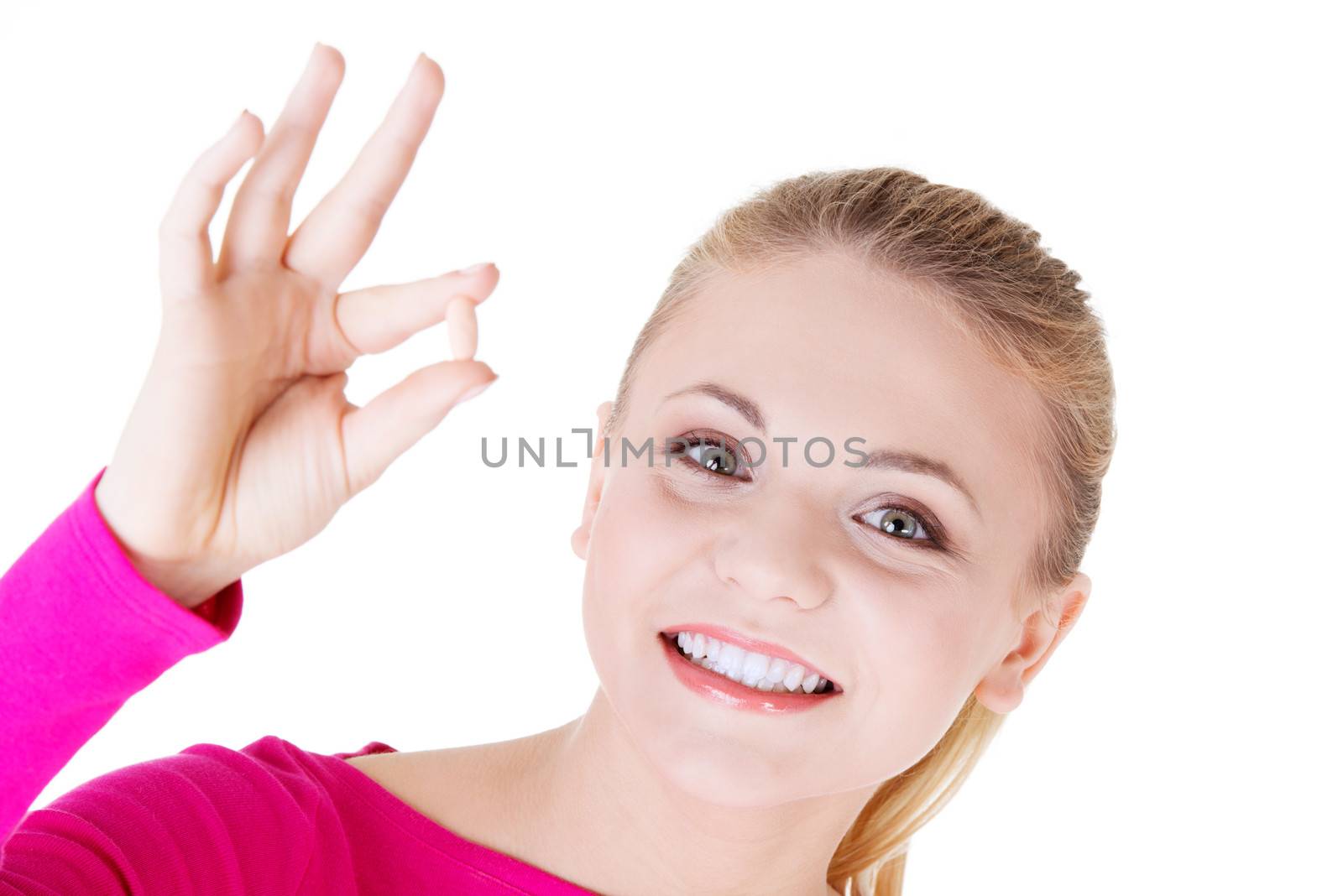 Young beautiful woman holding a pill. Isolated on white.