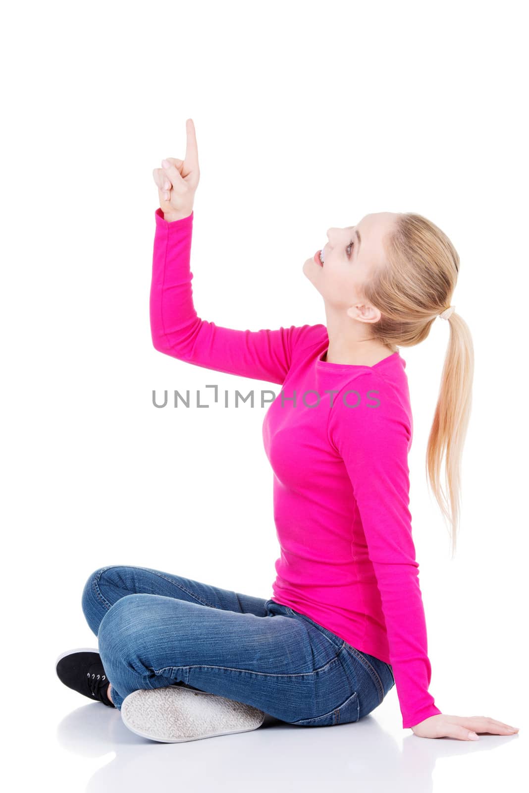 Young beautiful casual woman pointing up. by BDS