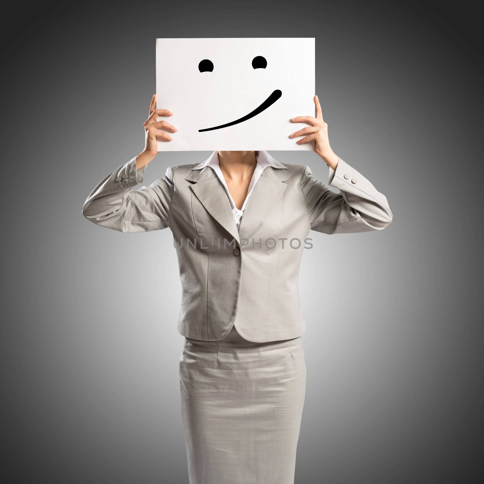 business woman holding a poster with a painted face on it instead of a face, the concept of duplicity in business