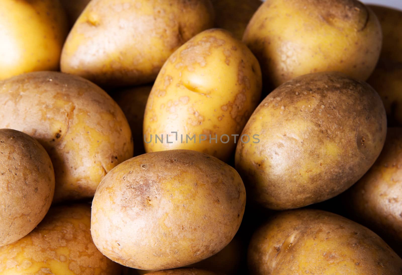Fresh potatoes.Over wooden background.