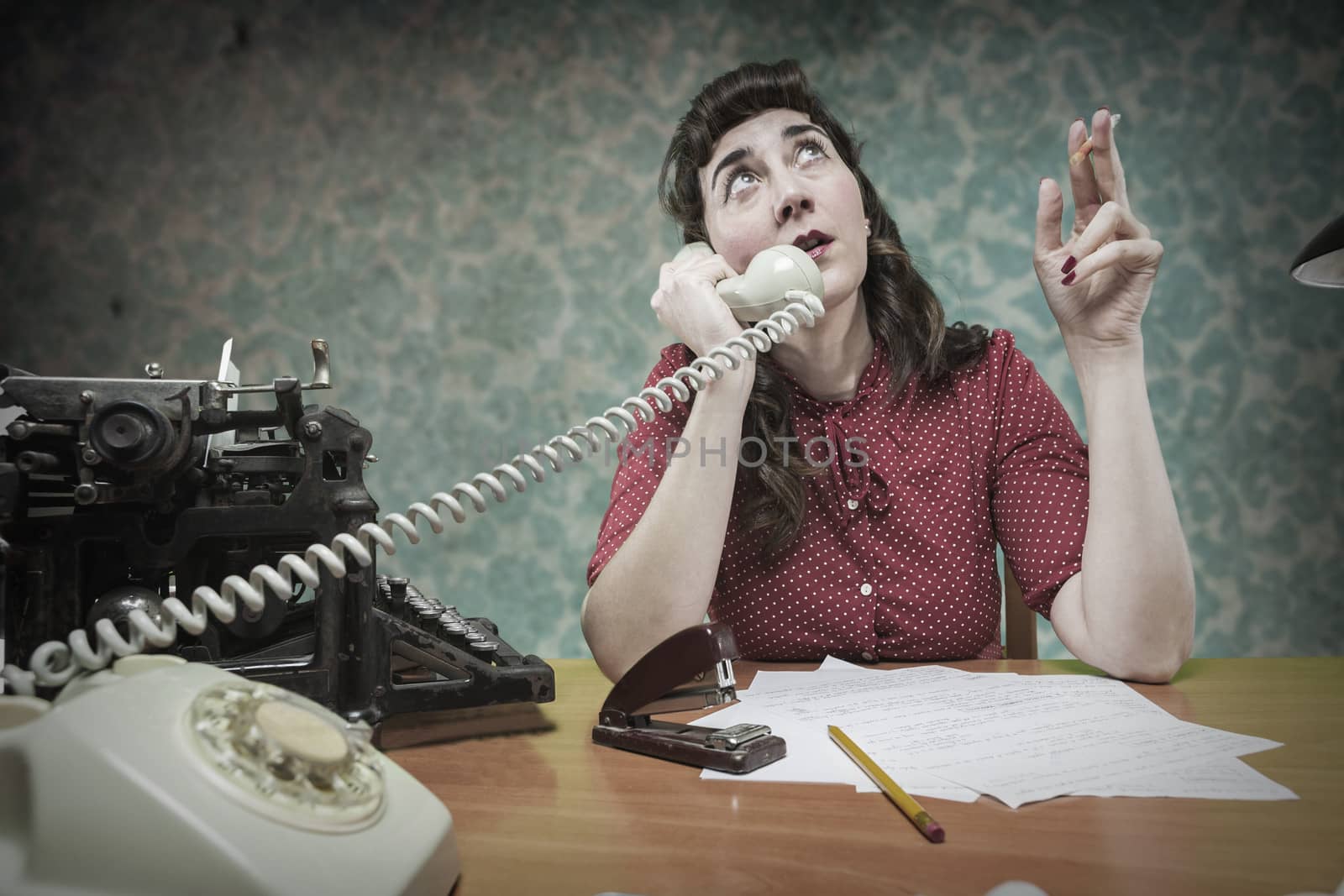 young Secretary smoking a cigarette while talking on the phone, 1960's scene