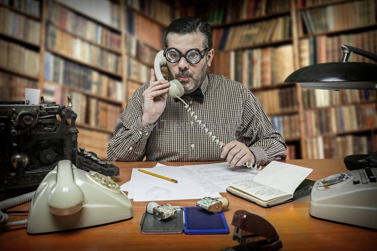 Employee with glasses talking on the phone in the office in the  by digicomphoto