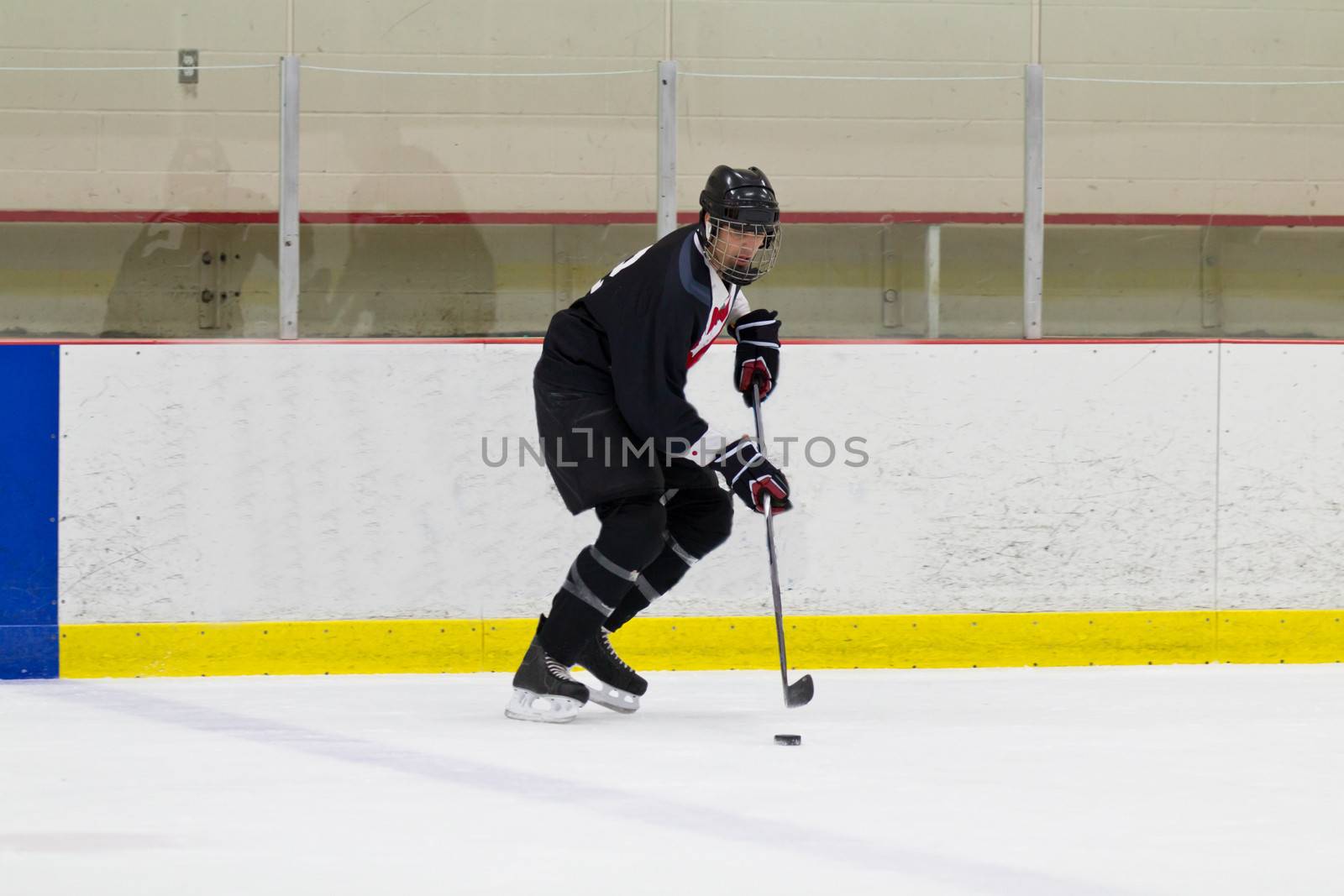 Male hockey player skating with the puck
