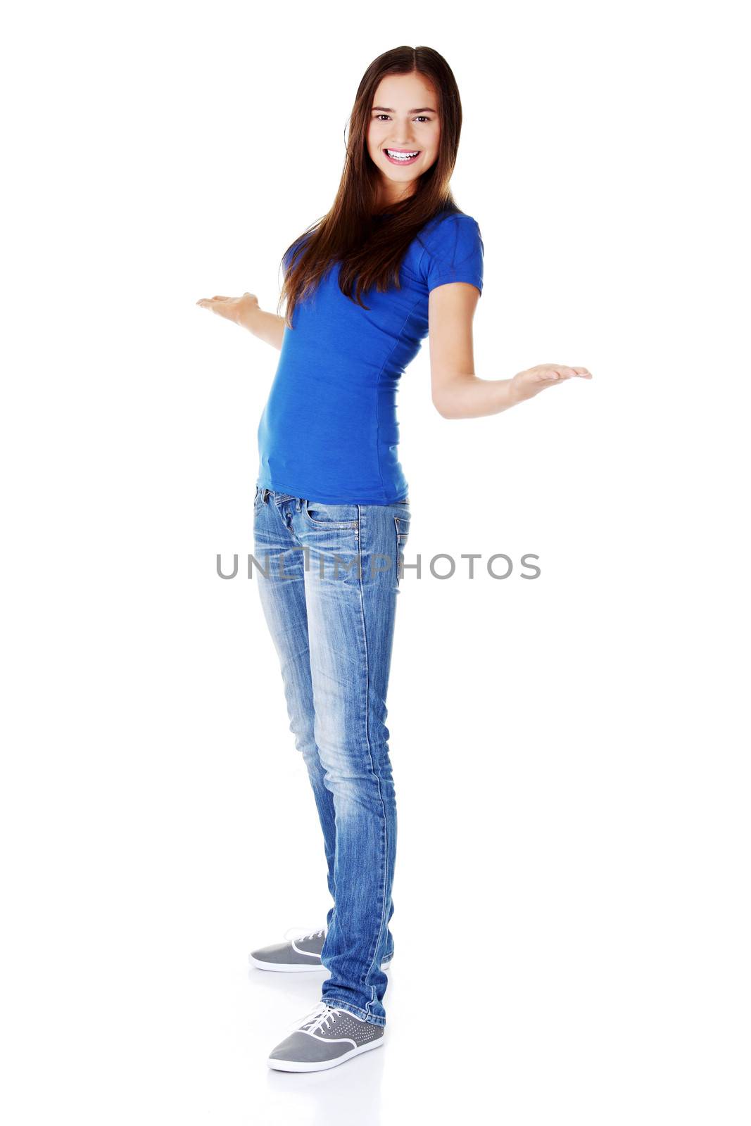 Young woman with her hands stretched and copy space on palms. Isolated on white.