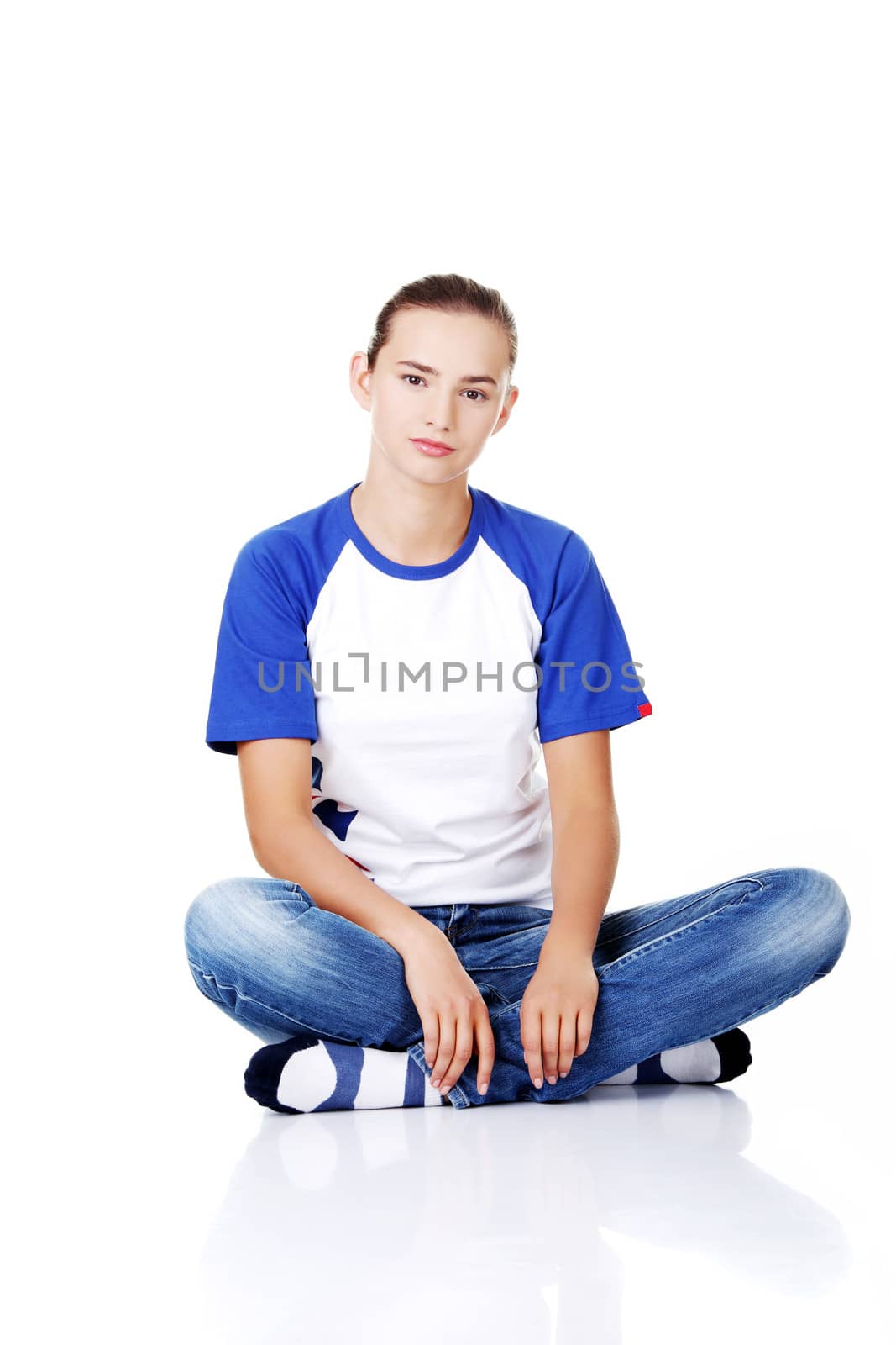 Beautiful young teenage woman sitting. Isolated on white.