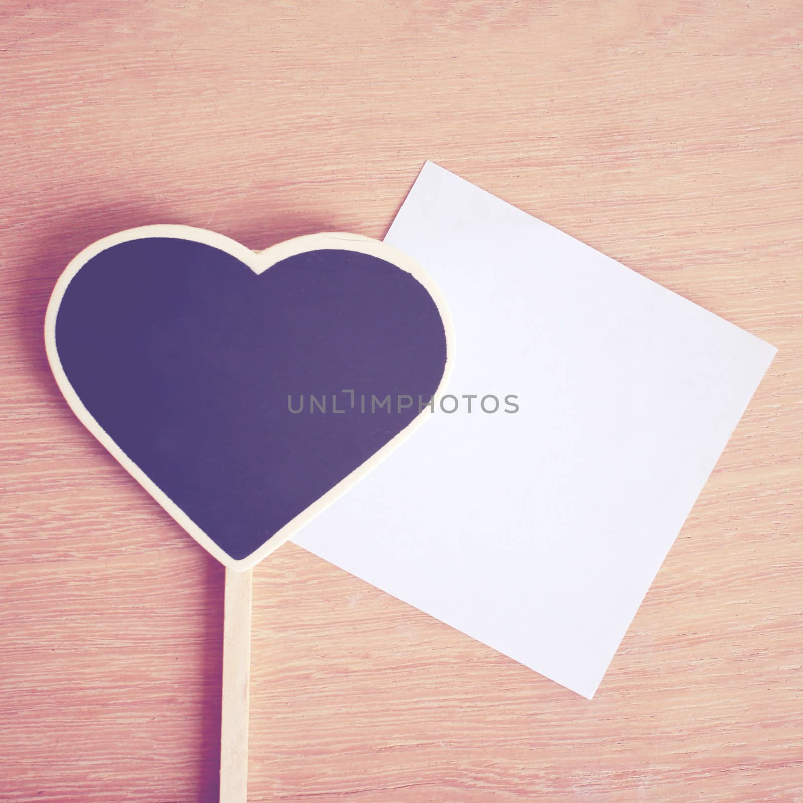 Heart shaped blackboard and note paper with copy space, retro filter effect 