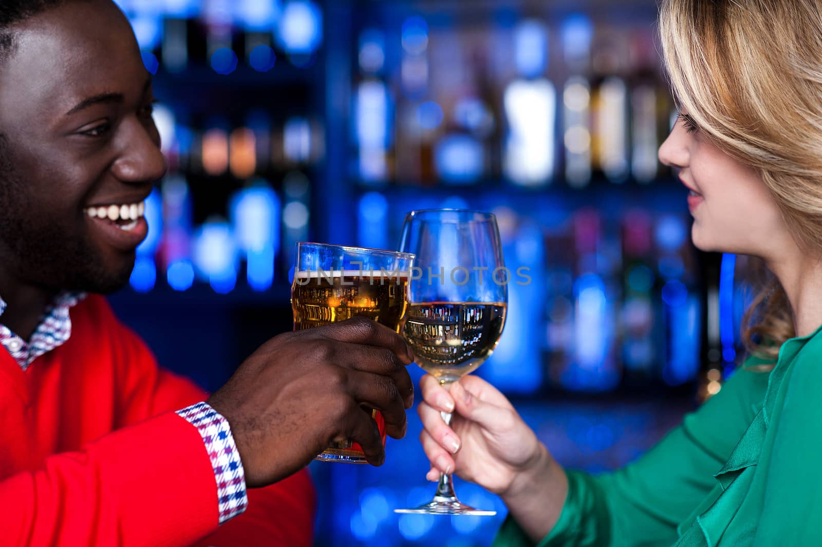 Young couple at a bar celebrating love by stockyimages