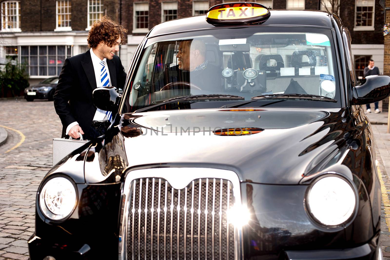 Corporate guy interacting with taxi driver by stockyimages