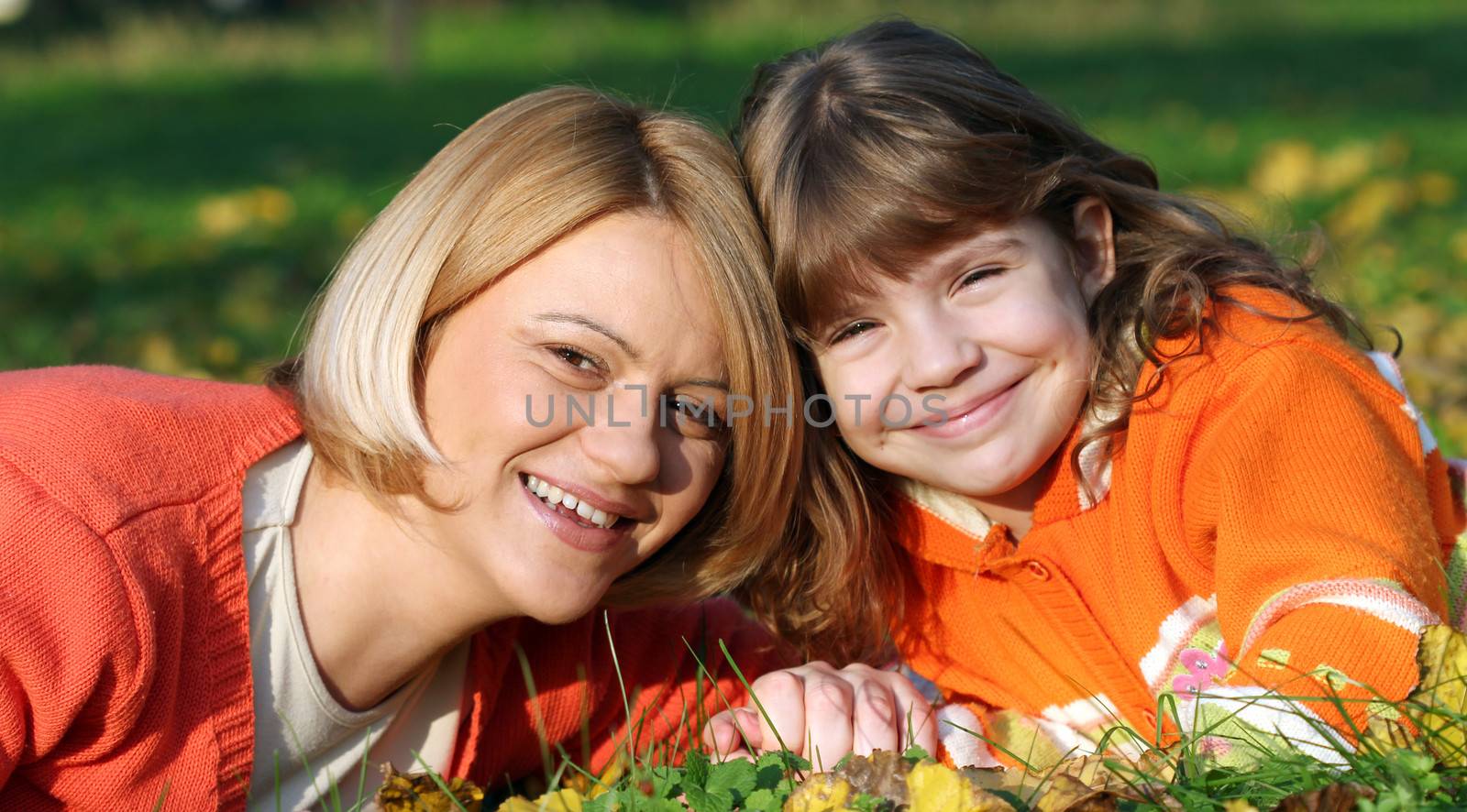 mother and daughter lying on grass