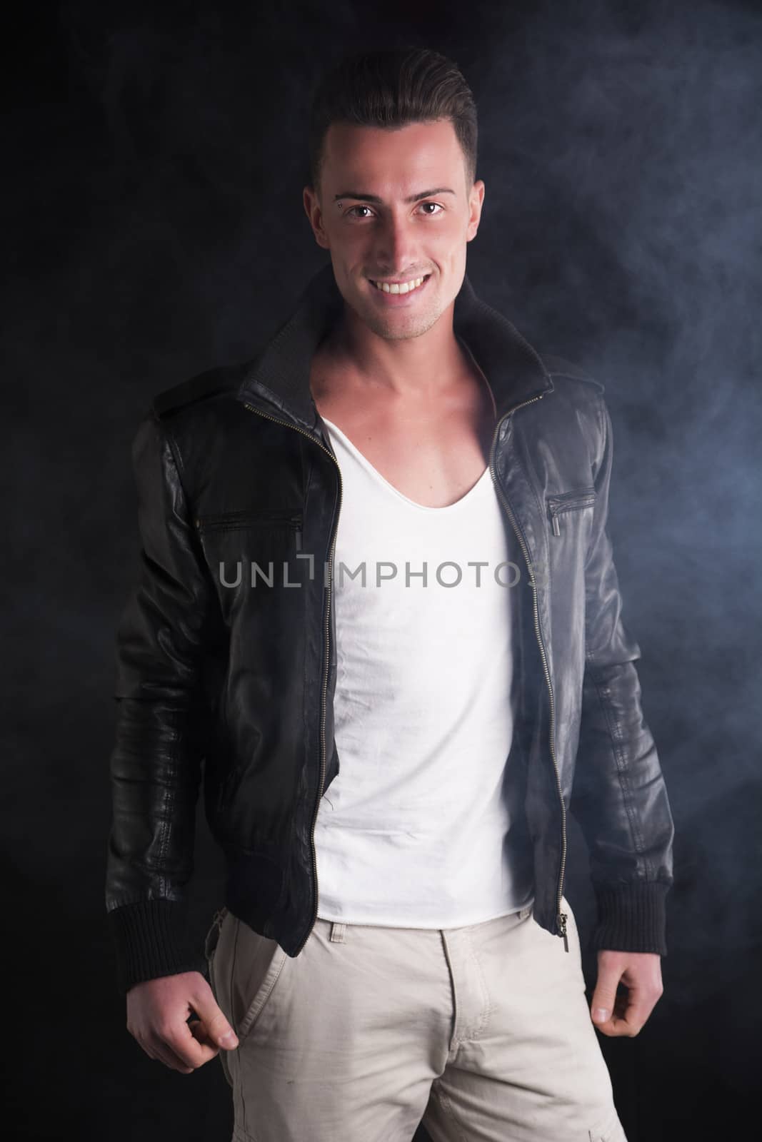 Smiling young man with white t-shirt and leather jacket by artofphoto