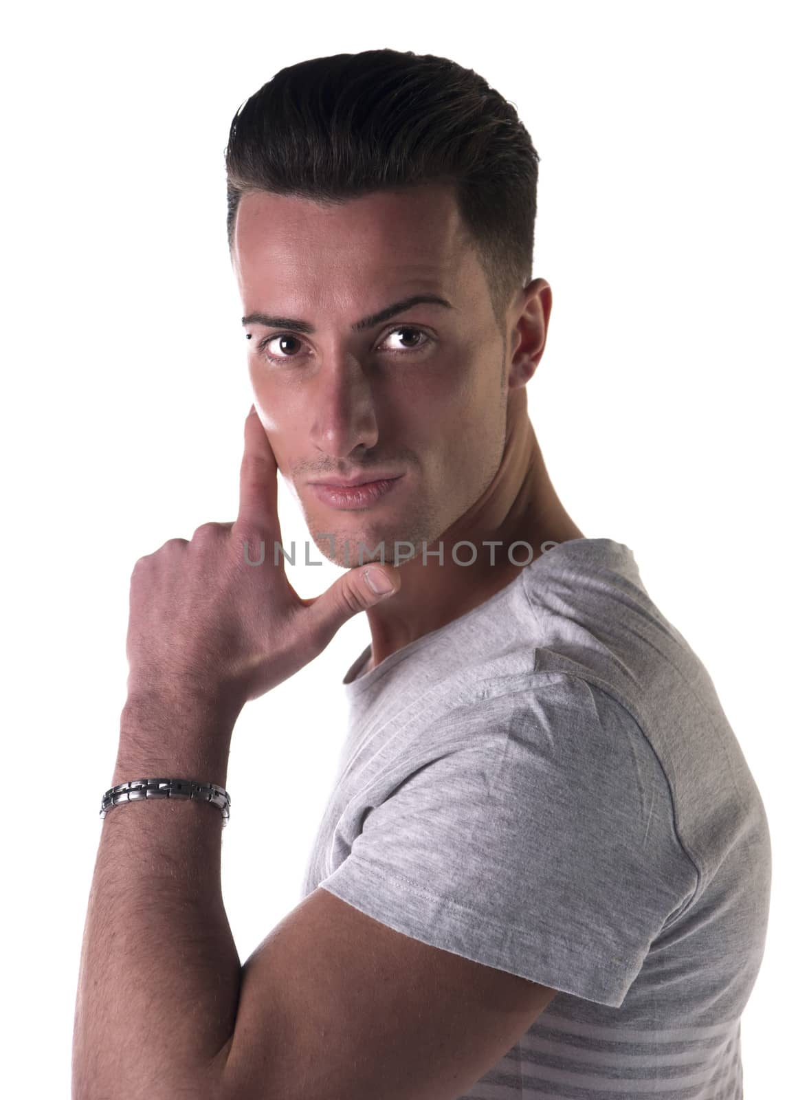Handsome young man looking at camera, hand on his chin, isolated on white
