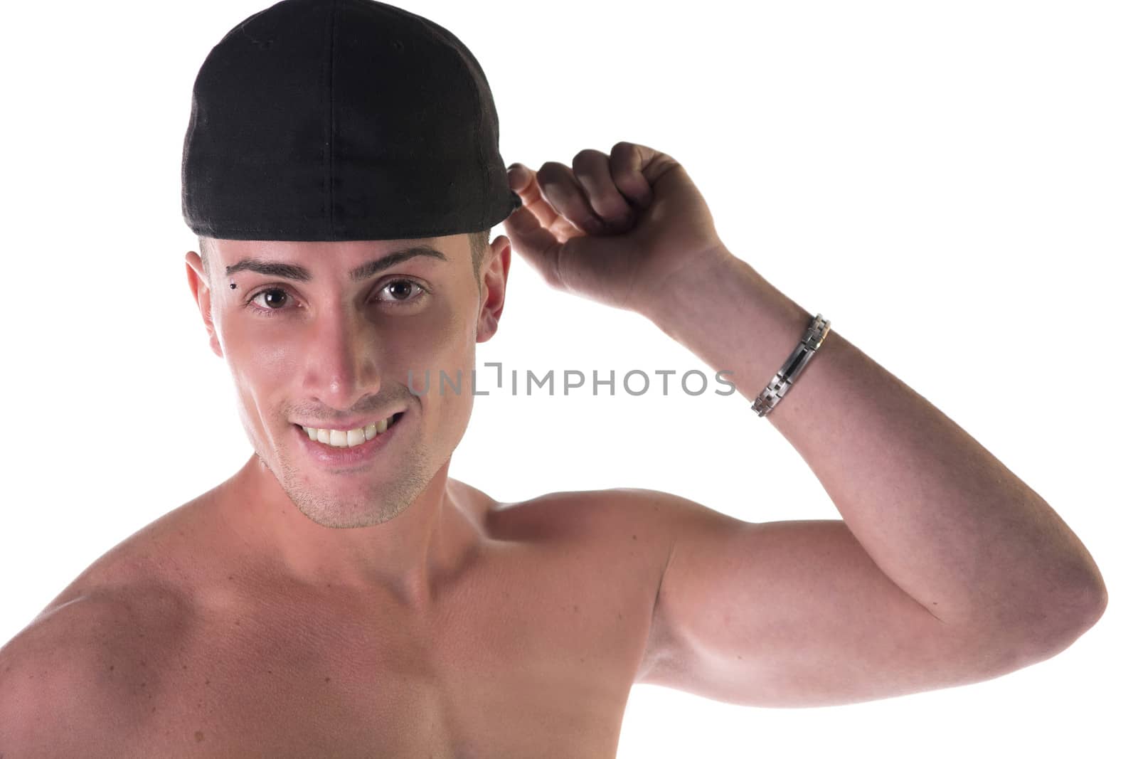 Shirtless young man smiling, touching his black baseball hat, isolated on white