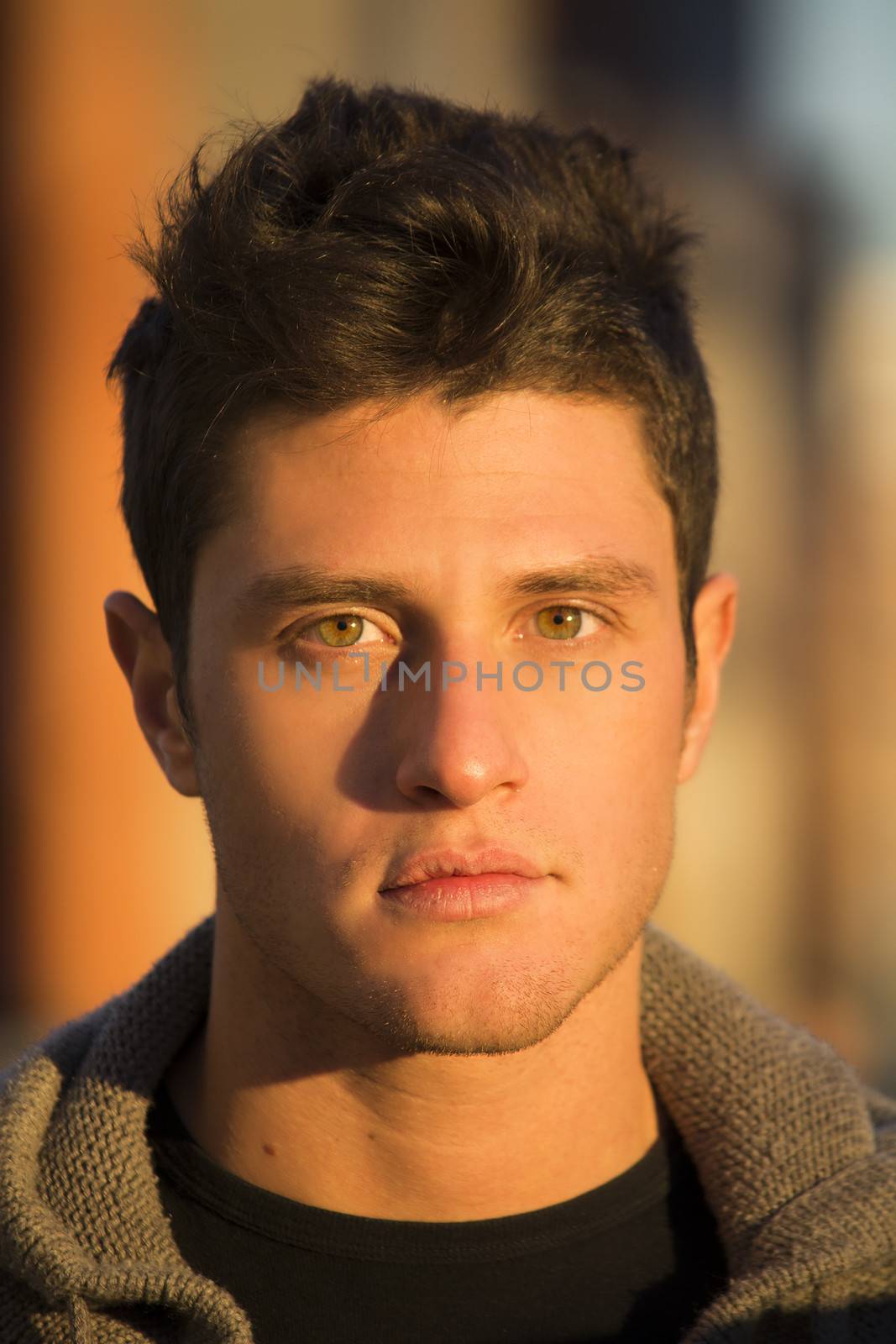 Headshot of handsome young man, lit by sunset light