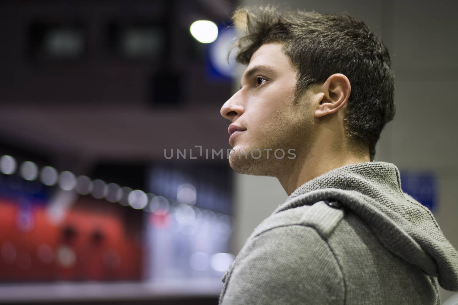 Profile shot of handsome young man inside train station looking away