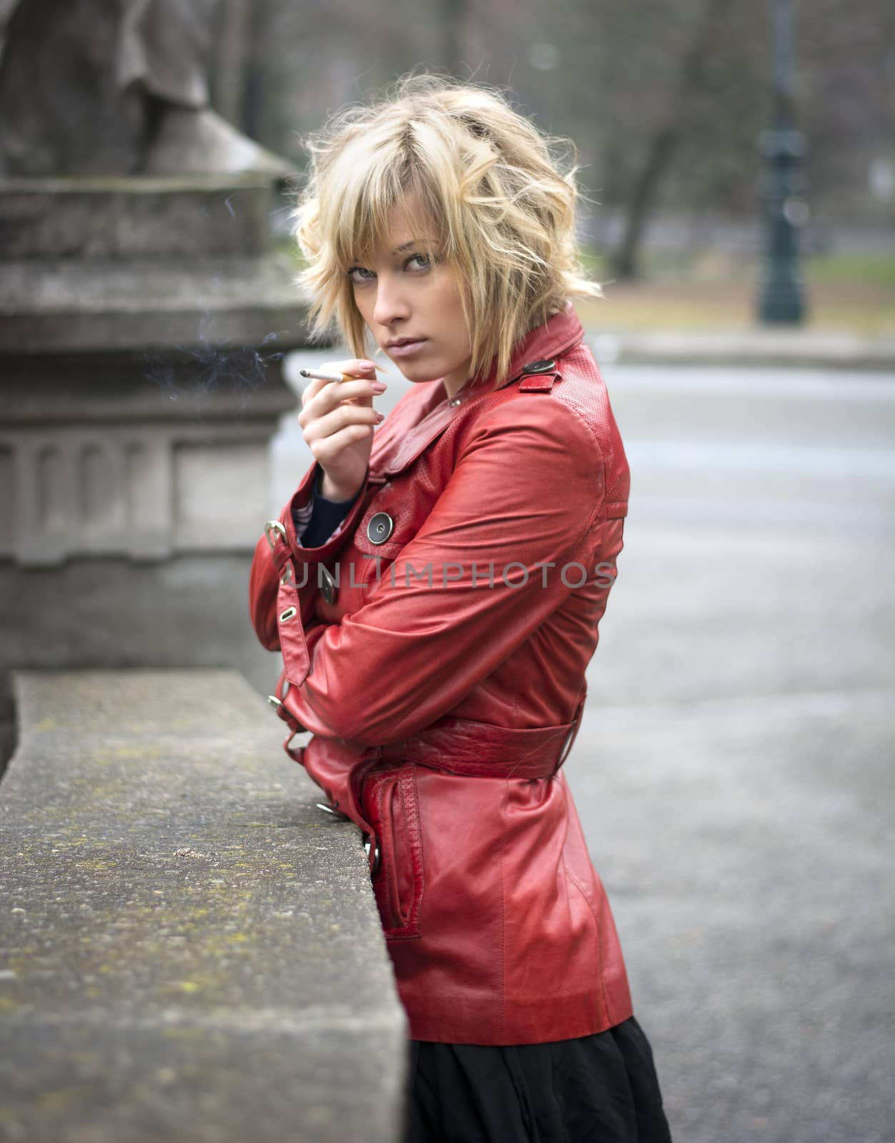 Pretty young woman smoking, wearing red leather jacket by artofphoto