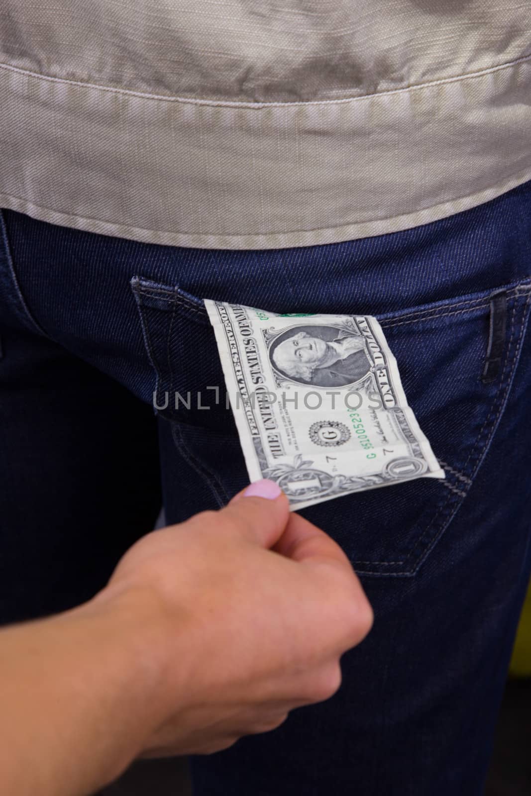 Thief takes out a dollar out of the pocket