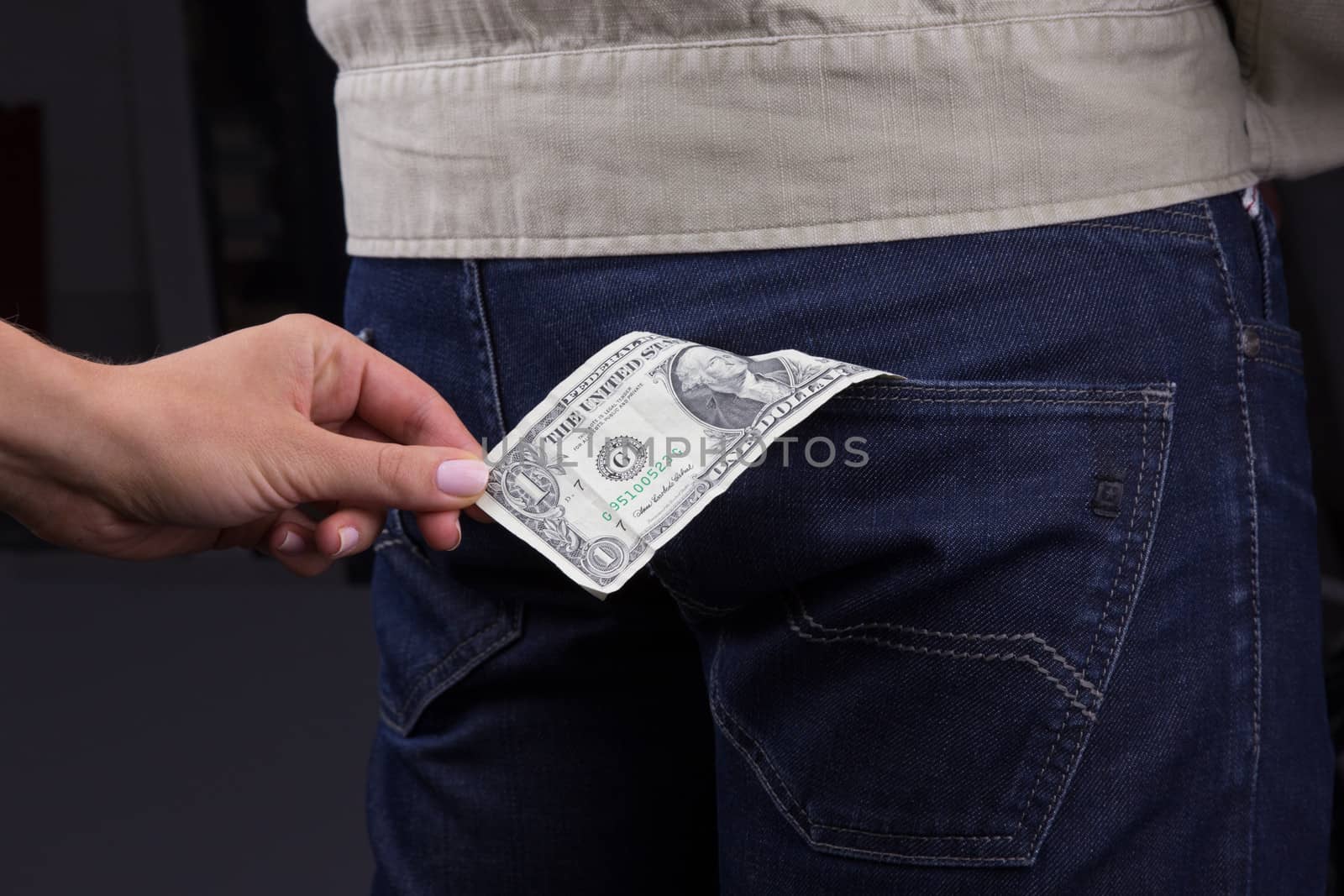 Thief takes out a dollar out of the pocket