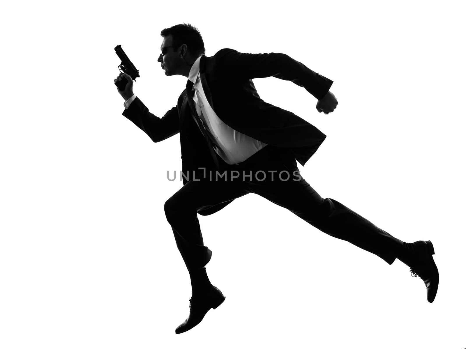 one caucasian man running with handgun  in silhouette  on white background