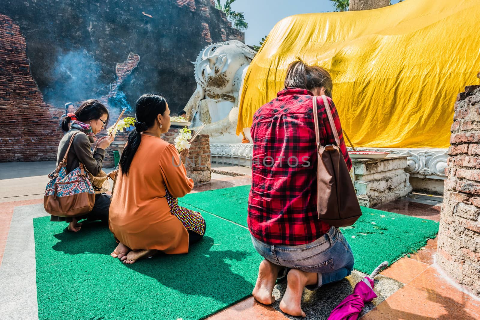 Bangkok, Thailand - December 29, 2013: people praying to the reclining buddha statue at Wat Yai Chaimongkol Ayutthaya in Bangkok, Thailand on december 29th, 2013